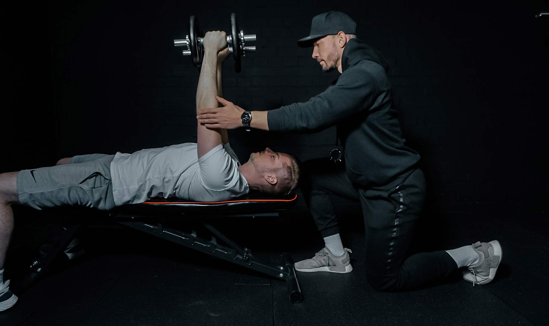 Personal Trainer Basti korrigiert seinen Kunden bei der Übung.